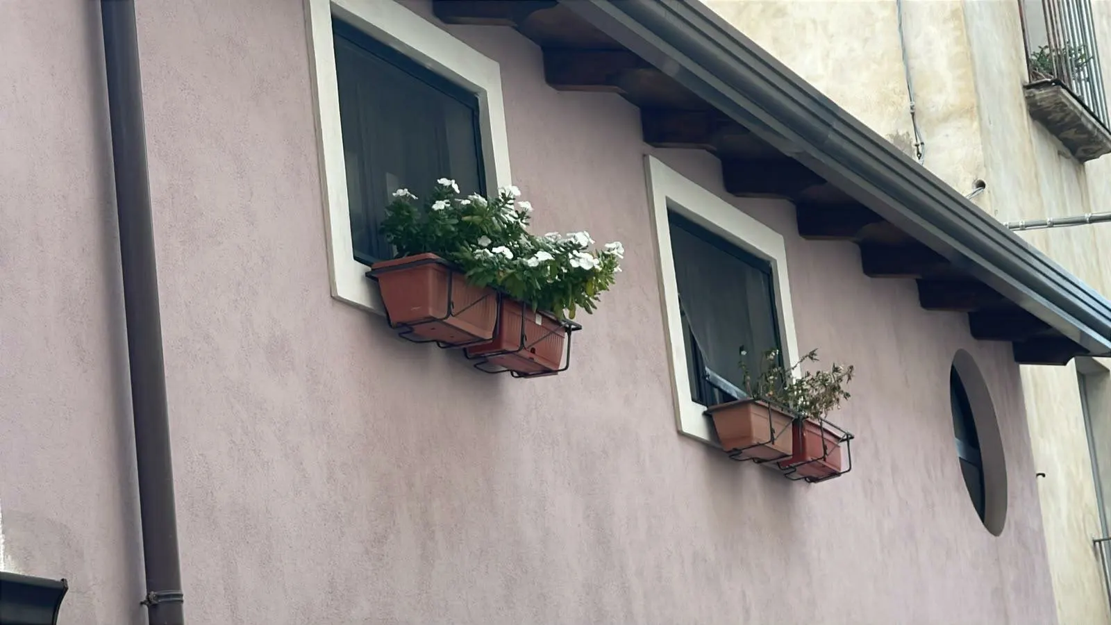 La facciata di una casa de Il Borgo con i fiori alle finestre